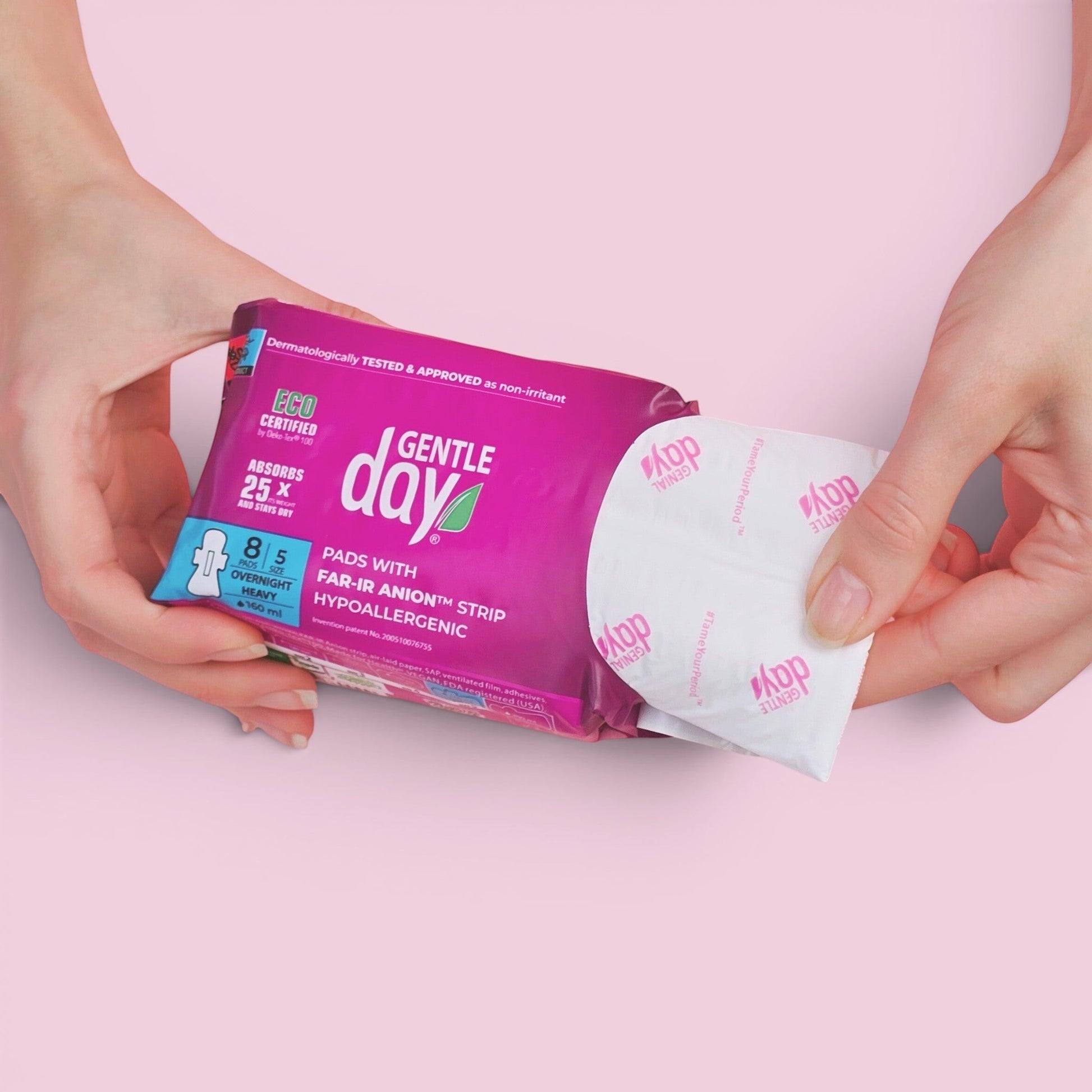 Hands holding a pack of Gentle Day in South Africa organic heavy flow overnight pads with an individually wrapped pad.
